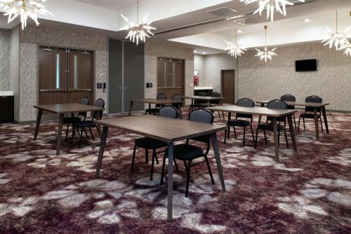 a conference room with tables and chairs and chandeliers at Hilton Garden Inn Gallatin in Gallatin