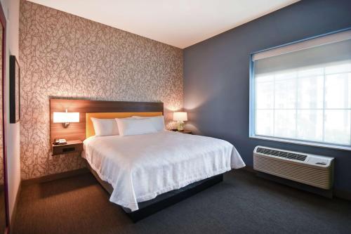 a hotel room with a bed and a window at Home2 Suites By Hilton Jekyll Island in Jekyll Island