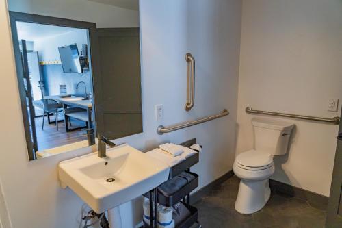 a bathroom with a sink and a toilet and a mirror at Gravity Haus Winter Park in Winter Park