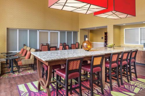 a large kitchen with a large island with bar chairs at Hampton Inn & Suites Charlotte Arrowood Rd in Charlotte