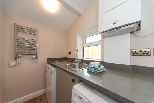 a kitchen with a sink and a window at The Bell Chime, renovated 3 bedroom cottage in Matlock in Matlock Bank