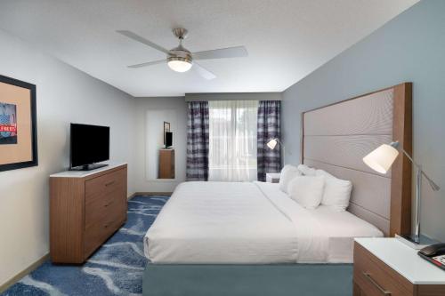 a hotel room with a bed and a flat screen tv at Homewood Suites Memphis Germantown in Memphis