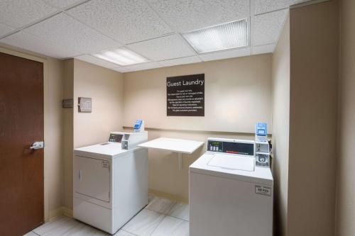 a laundry room with a washer and dryer and a sign at Homewood Suites Memphis Germantown in Memphis
