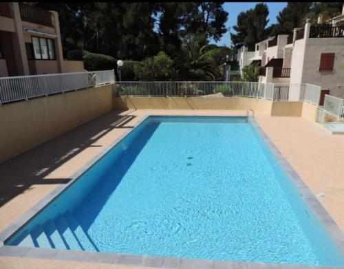 une grande piscine bleue dans un bâtiment dans l'établissement STUDIO 110 GRANDE TERRASSE PROCHE MER, à Bandol