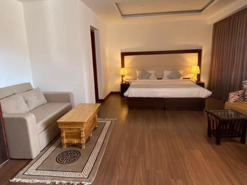 a hotel room with a bed and a couch at Lha-Zes in Leh