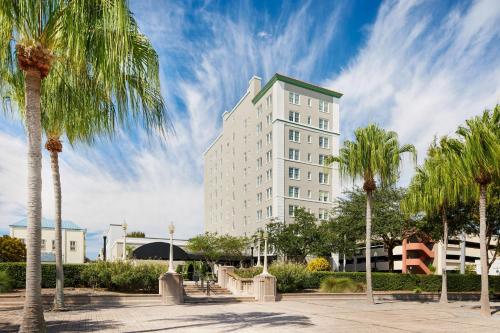 レイクランドにあるThe Terrace Hotel Lakeland, Tapestry Collection by Hiltonのヤシの木が前に立つ背の高い白い建物