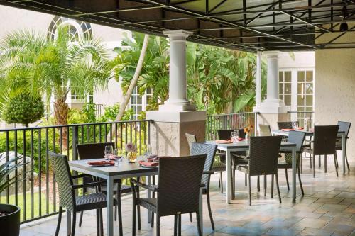 ein Restaurant mit Tischen und Stühlen auf einer Terrasse in der Unterkunft The Terrace Hotel Lakeland, Tapestry Collection by Hilton in Lakeland