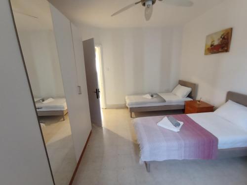 um pequeno quarto com 2 camas e um espelho em Spacious Vila in Swiqi em Is-Swieqi