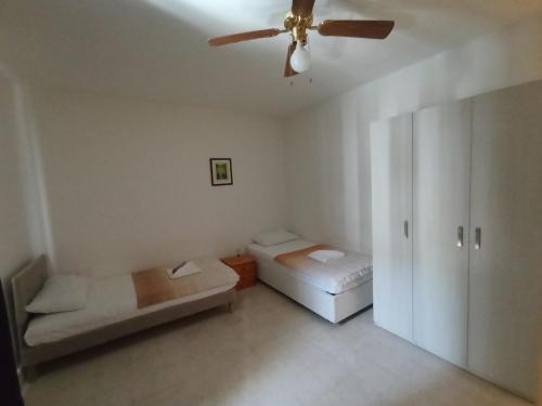 uma sala de estar com uma ventoinha de tecto e um sofá em Spacious Vila in Swiqi em Is-Swieqi