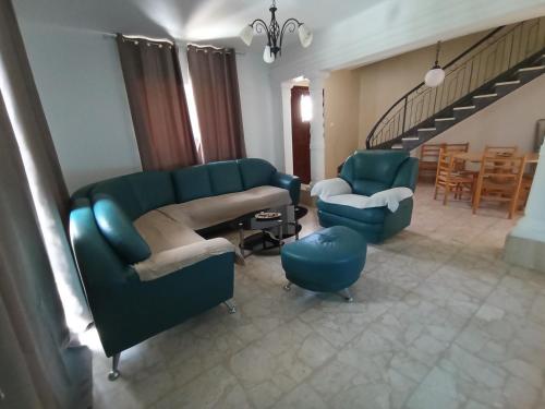 uma sala de estar com duas cadeiras azuis e uma escada em Spacious Vila in Swiqi em Is-Swieqi