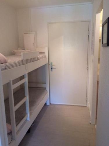 Cette chambre comprend 2 lits superposés et une porte. dans l'établissement STUDIO 110 GRANDE TERRASSE PROCHE MER, à Bandol