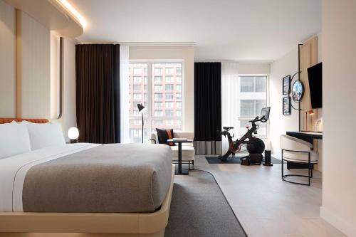 Cette chambre comprend un lit et un bureau avec un tapis de course. dans l'établissement Canopy By Hilton Toronto Yorkville, à Toronto