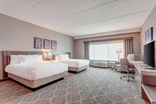 Habitación de hotel con 2 camas y escritorio en Hilton Garden Inn Toronto/Brampton West, Ontario, Canada, en Brampton