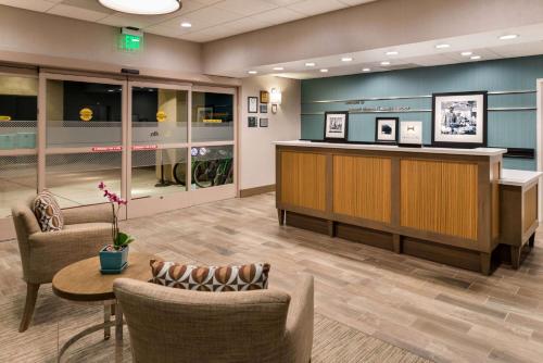 a lobby with chairs and a reception desk and a table at Hampton Inn Channel Islands Harbor in Oxnard