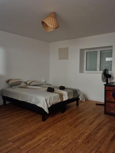 1 dormitorio con 1 cama y suelo de madera en Chez Lofred 1, en Four