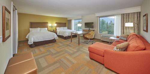 a hotel room with a bed and a couch at Hampton Inn & Suites Hood River in Hood River