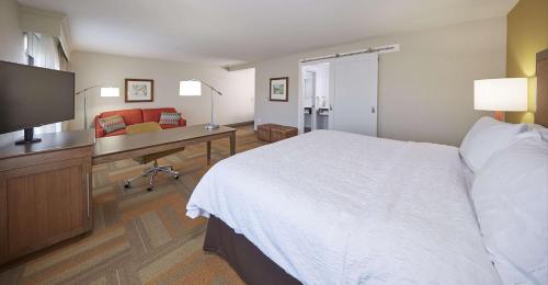 a hotel room with a bed and a desk with a computer at Hampton Inn & Suites Hood River in Hood River