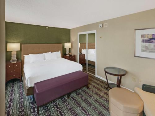 a hotel room with a bed and a table and chairs at Hilton Harrisburg near Hershey Park in Harrisburg