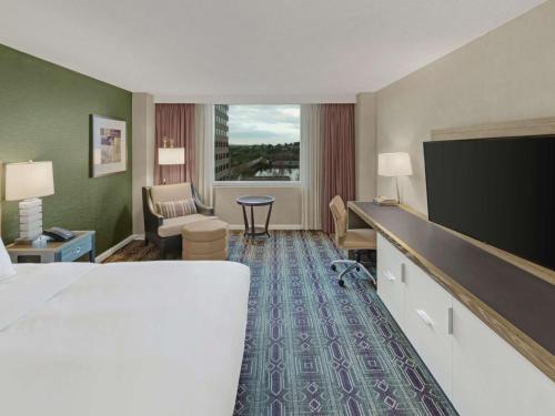 a hotel room with a bed and a flat screen tv at Hilton Harrisburg near Hershey Park in Harrisburg