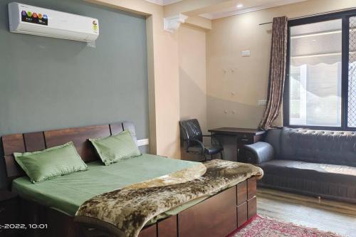 a bedroom with a bed with a couch and a window at 3 Luxury BedRoom Set OSHO Villa Jaipur Airport in Jaipur