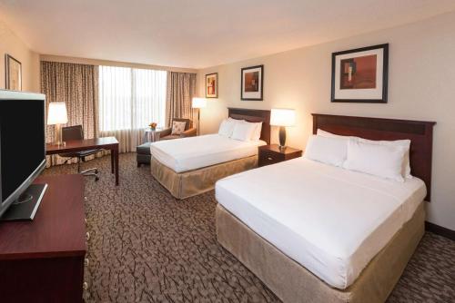 a hotel room with two beds and a flat screen tv at DoubleTree by Hilton Lafayette in Lafayette