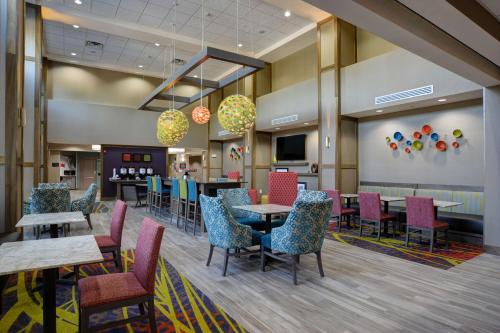 a dining room with tables and chairs in a cafeteria at Hampton Inn & Suites Ardmore in Ardmore