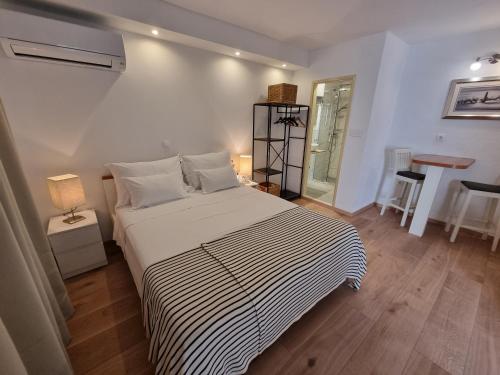 ein Schlafzimmer mit einem Bett mit einer schwarz-weißen gestreiften Decke in der Unterkunft Studio Riva in Hvar