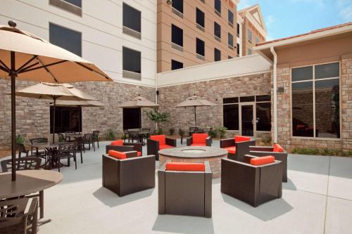 an outdoor patio with tables and chairs and umbrellas at Hilton Garden Inn Springfield, MO in Springfield