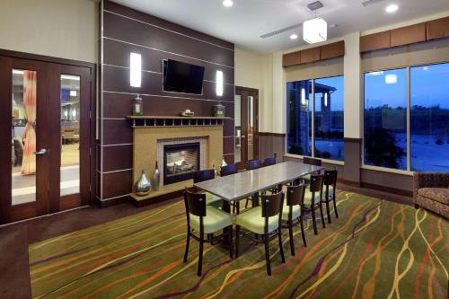 a dining room with a fireplace and a table and chairs at Hilton Garden Inn Springfield, MO in Springfield