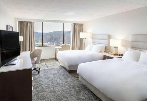 DoubleTree by Hilton Charlottesville في شارلوتسفيل: غرفة فندقية بسريرين وتلفزيون بشاشة مسطحة