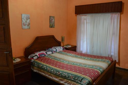 ein Schlafzimmer mit einem Bett mit einer bunten Decke darauf in der Unterkunft CASA LA QUEBRADA in Cordoba