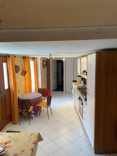 une cuisine et une salle à manger avec une table et une table et des chaises dans l'établissement Family friendly house in Brenac, à Quillan