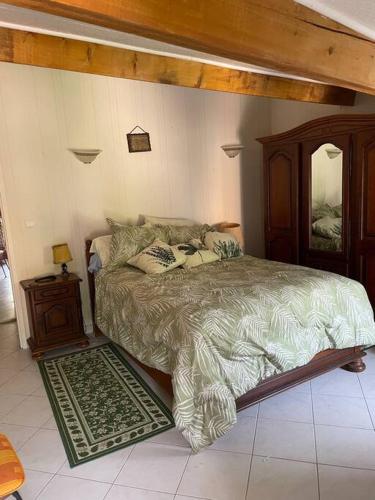 - une chambre avec un grand lit et un cadre en bois dans l'établissement Family friendly house in Brenac, à Quillan