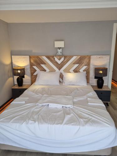 ein Schlafzimmer mit einem großen weißen Bett mit zwei Lampen in der Unterkunft Lemon Garden Boutique Hotel in Bozburun