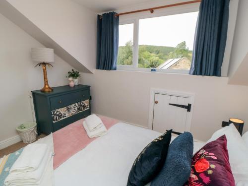 a bedroom with a large bed with a window at Goosedale Cottage in Scarborough