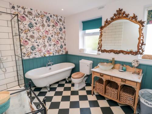 a bathroom with a tub and a toilet and a sink at Goosedale Cottage in Scarborough