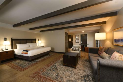 Estancia del Norte San Antonio, A Tapestry Hotel by Hilton في سان انطونيو: غرفه فندقيه بسرير واريكه