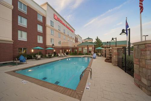 a hotel with a swimming pool in front of a building at Hilton Garden Inn Lawton-Fort Sill in Lawton