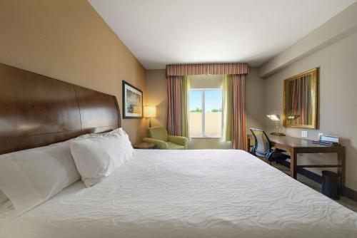 ein Hotelzimmer mit einem großen Bett und einem Schreibtisch in der Unterkunft Hilton Garden Inn Lawton-Fort Sill in Lawton