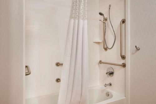 a bathroom with a shower with a white shower curtain at Hampton Inn & Suites Cleveland-Independence in Independence