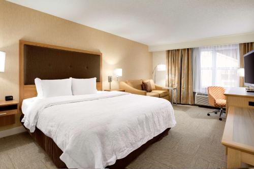 a hotel room with a large bed and a chair at Hampton Inn & Suites Cleveland-Independence in Independence