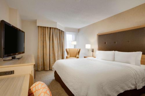 a hotel room with a bed and a flat screen tv at Hampton Inn & Suites Cleveland-Independence in Independence