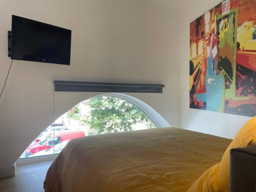 a bedroom with a bed and a flat screen tv at Studio Au Clair de Lune in Saint-Alban-de-Roche