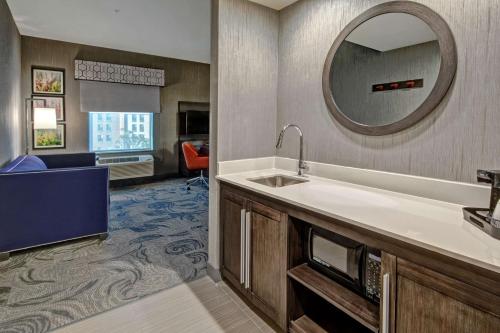 Cette chambre d'hôtel comprend un lavabo et un miroir. dans l'établissement Hampton Inn Fresno Airport, à Fresno