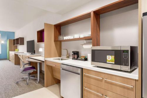 a kitchen with a counter with a microwave and a desk at Home2 Suites By Hilton Harrisburg Hershey in Harrisburg