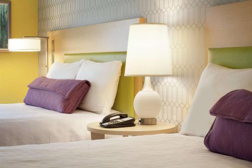 a hotel room with two beds and a lamp on a table at Home2 Suites by Hilton Salt Lake City-East in Salt Lake City