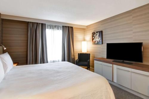 a hotel room with a bed and a flat screen tv at Hilton Garden Inn Toronto/Mississauga in Mississauga