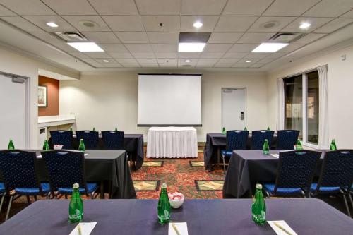 a conference room with tables and chairs and a white screen at Hilton Garden Inn Toronto/Mississauga in Mississauga