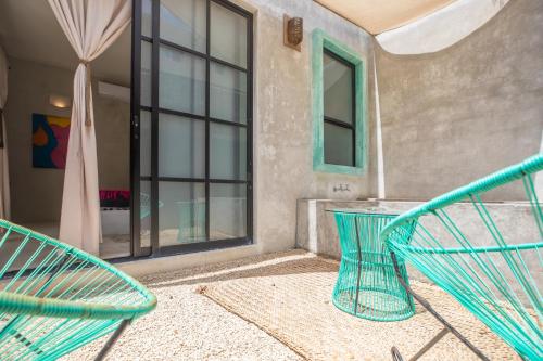 a patio with two chairs and a table at Turquoise Tulum Hotel in Tulum
