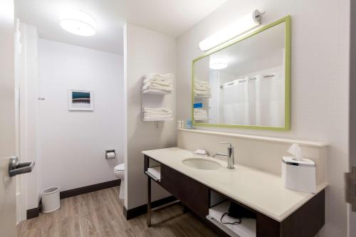 a bathroom with a sink and a mirror at Hampton Inn Bismarck in Bismarck